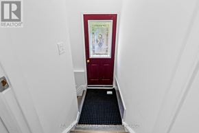 Niagara Falls (Ascot) house for rent - A red door with a painting on it in a white hallway.