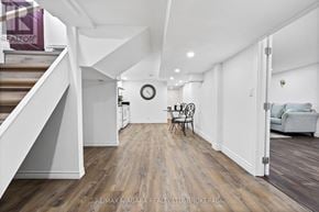 Niagara Falls (Ascot) house for rent - A spacious room with a staircase on the left and a couch on the right.