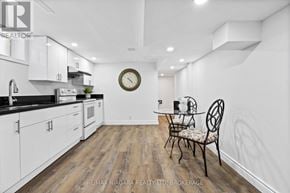 Niagara Falls (Ascot) house for rent - A kitchen with white cabinets and a black countertop.