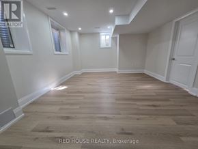 Milton (Cb Cobban) house for rent - A spacious room with wooden flooring and white walls.