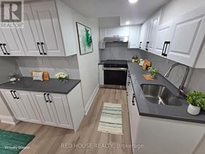 Milton (Cb Cobban) house for rent - A kitchen with white cabinets and a black countertop.
