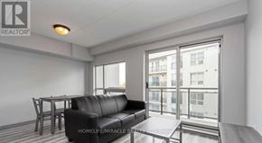 Waterloo condo for rent - A living room with a black leather sofa and a wooden table.