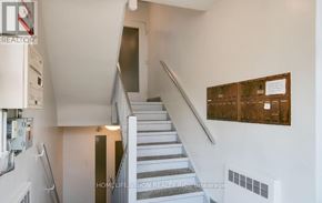 Toronto (Leaside) house for rent - A staircase with a metal railing and a wall with a brown panel on it.