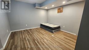 Niagara Falls (Brown) house for rent - A bedroom with a bed on a wooden floor.