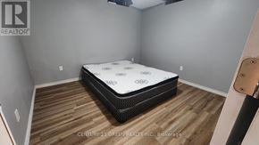 Niagara Falls (Brown) house for rent - A bedroom with a bed and wooden flooring.