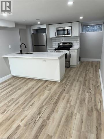 Brantford house for rent - A kitchen with a white counter top and wooden flooring.