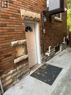Brantford house for rent - A brick building with a white door and a black mat on the sidewalk.