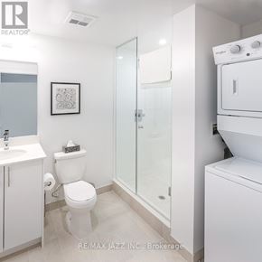 Oshawa (O'neill) condo for rent - A white bathroom with a toilet, sink, and shower.