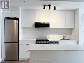 Ottawa multi-family for rent - A modern kitchen with white cabinets and stainless steel appliances.