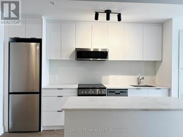 Ottawa multi-family for rent - A modern kitchen with white cabinets and stainless steel appliances.