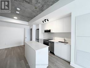 Ottawa multi-family for rent - A modern kitchen with white cabinets and a large island.