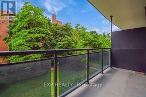 Mississauga (Cooksville) multi-family for rent - A balcony with a black railing and a view of a green lawn and trees.