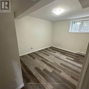 Ottawa triplex for rent - A room with wooden flooring and a window.