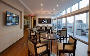 Atlanta apartment for rent - a lounge area with tables and chairs and a television