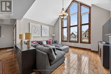 Blue Mountains house for rent - A living room with a grey couch and a chandelier.