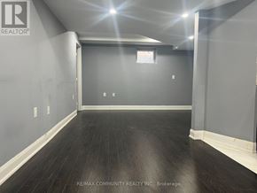 Ajax (Northwest Ajax) multi-family for rent - A spacious room with dark wood flooring and white walls.