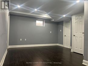 Ajax (Northwest Ajax) multi-family for rent - A room with grey walls and wooden flooring, with a window and two doors.