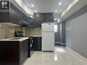 Ajax (Northwest Ajax) multi-family for rent - A kitchen with a white refrigerator, dark brown cabinets, and a marble floor.