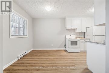 Burlington (Freeman) other for rent - A kitchen with white cabinets and a wooden floor.