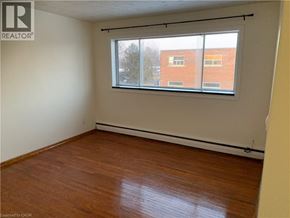 Cambridge apartment for rent - Empty room with a window and wooden flooring.