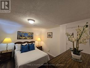 Toronto (Malvern) house for rent - A bedroom with a bed, nightstands, and a painting on the wall.