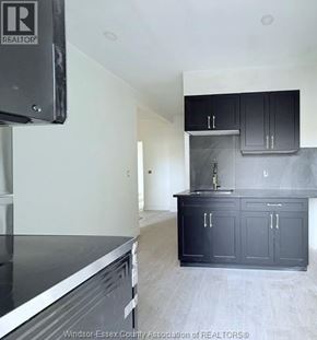 Windsor apartment for rent - A kitchen with black cabinets and a stainless steel dishwasher.