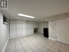 Toronto (Caledonia-Fairbank) house for rent - A spacious, empty room with white walls and tile flooring.