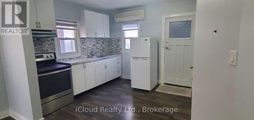 Toronto (Weston) house for rent - A kitchen with white cabinets and a black countertop.