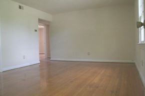 Newport News apartment for rent - an empty living room with white walls and wooden floors