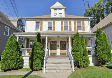 Englewood apartment for rent - A white house with a brown roof and a brown door.