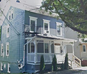 Poughkeepsie apartment for rent - A blue house with a white porch and a tree in front.