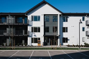 Westbank apartment for rent - A white building with a black roof and a balcony on the left side.