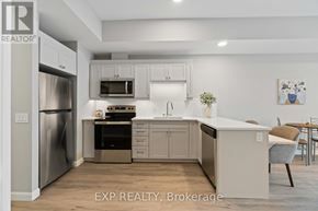 For rent in Perth - A kitchen with white cabinets and a stainless steel refrigerator.