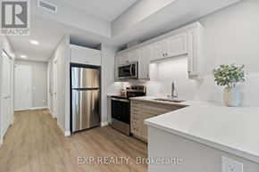 For rent in Perth - A kitchen with white cabinets and a stainless steel refrigerator.