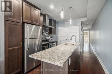 Ottawa triplex for rent - A kitchen with wooden cabinets and a marble countertop.