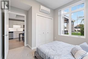 For rent in Perth - A bedroom with a large bed and a kitchen area in the background.