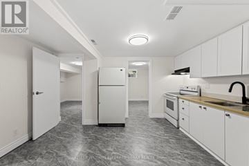 Mississauga (Mississauga Valleys) house for rent - A kitchen with white cabinets and a marble floor.