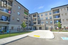 Amherstburg apartment for rent - A large apartment complex with a parking lot in front.