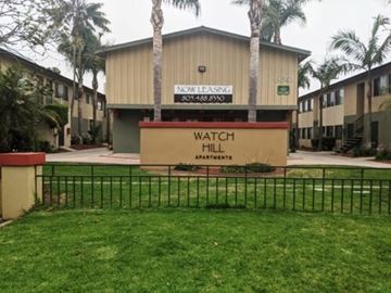 Port Hueneme apartment for rent - Watch Hill Apartments is a beige building with a sign in front.