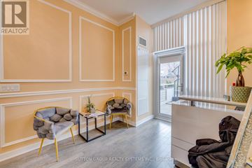 Richmond Hill (Langstaff) condo for rent - A living room with a grey chair and a small table with a plant on it.