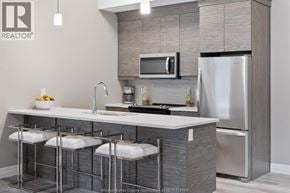Tecumseh condo for rent - A modern kitchen with a stainless steel refrigerator and a white countertop.