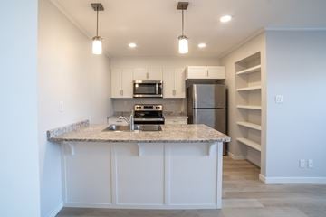 Saskatoon apartment for rent - A kitchen with a granite countertop and stainless steel appliances.