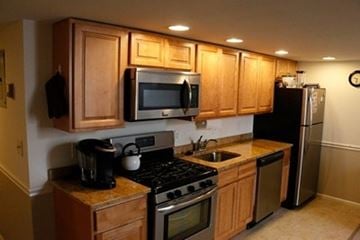 Metuchen apartment for rent - A kitchen with wooden cabinets and stainless steel appliances.