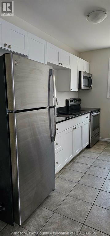 Windsor duplex for rent - A kitchen with white cabinets and a stainless steel refrigerator.
