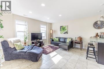 Windsor duplex for rent - A living room with a grey couch and a black chair.
