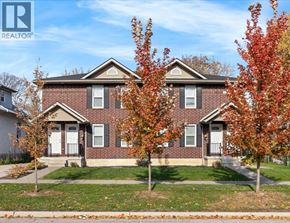 Windsor duplex for rent - A house with a lawn and trees in front of it.