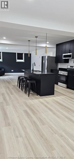Windsor house for rent - A kitchen with black cabinets and a white refrigerator.