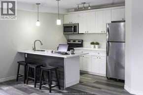 Windsor triplex for rent - A kitchen with a bar stool and a laptop on the counter.