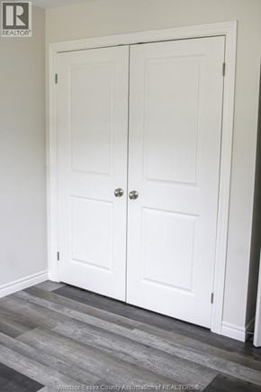 Windsor triplex for rent - A white double door with a silver handle is in a room with a wooden floor.