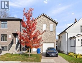 Windsor house for rent - A tree with red leaves is in front of a brick house with a car parked in front of it.